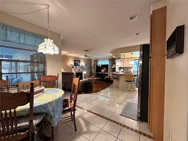 dining room with ceiling fan, light tile patterned flooring, and a textured ceiling