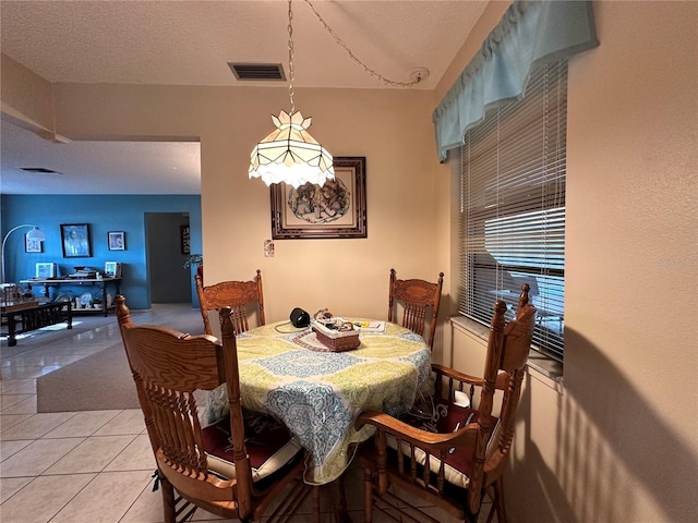 dining space with light tile patterned floors and a textured ceiling