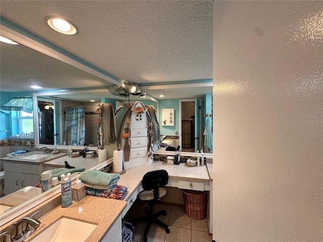 interior space with vanity, tile patterned flooring, ceiling fan, walk in shower, and a textured ceiling