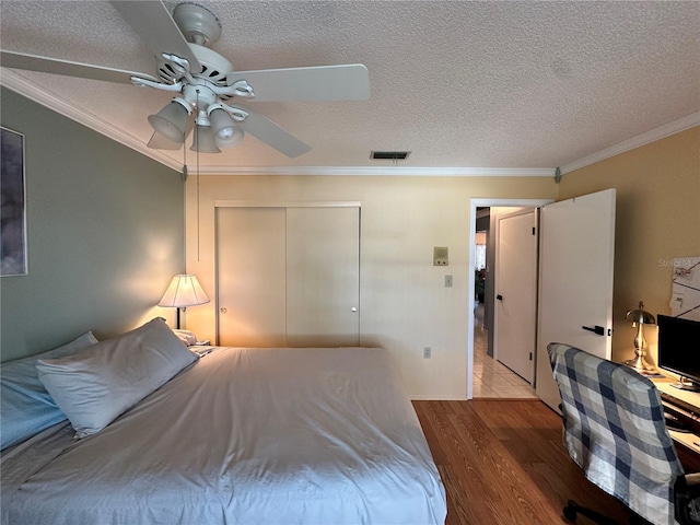 bedroom featuring a closet, ceiling fan, crown molding, and light hardwood / wood-style floors