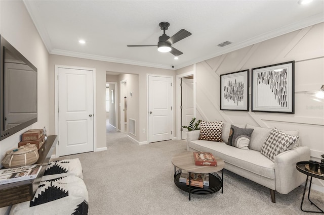 carpeted living room with ceiling fan and ornamental molding