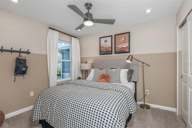 carpeted bedroom featuring ceiling fan and a closet