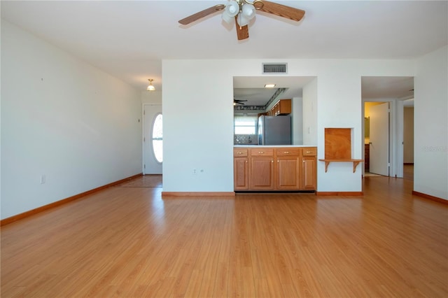 unfurnished living room featuring ceiling fan and light hardwood / wood-style floors