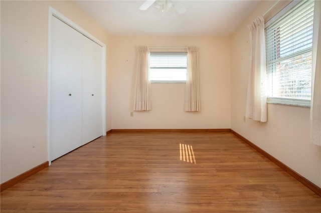 unfurnished bedroom with hardwood / wood-style flooring, ceiling fan, and a closet