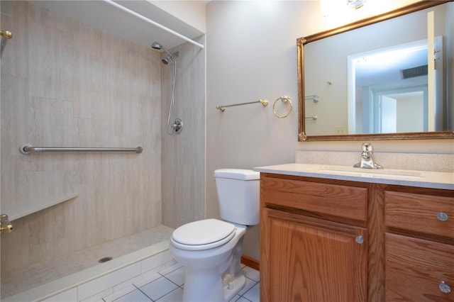 bathroom featuring tile patterned flooring, vanity, tiled shower, and toilet