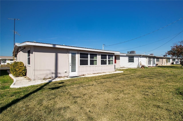 rear view of property featuring a yard