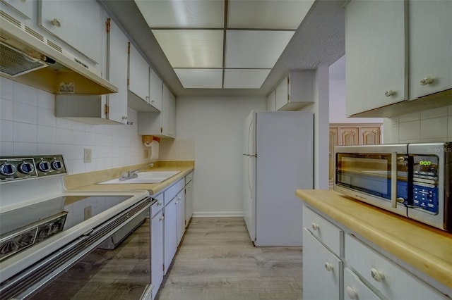 kitchen with white fridge, tasteful backsplash, light wood-type flooring, electric range oven, and white cabinets