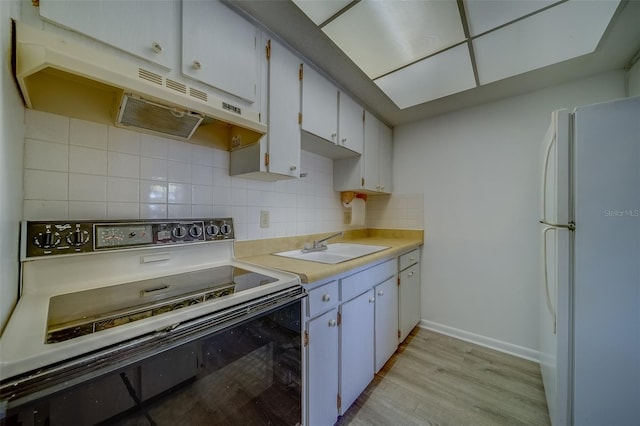 kitchen featuring white refrigerator, sink, white cabinetry, backsplash, and black / electric stove