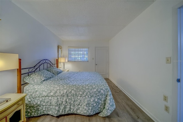 bedroom featuring a textured ceiling and hardwood / wood-style floors