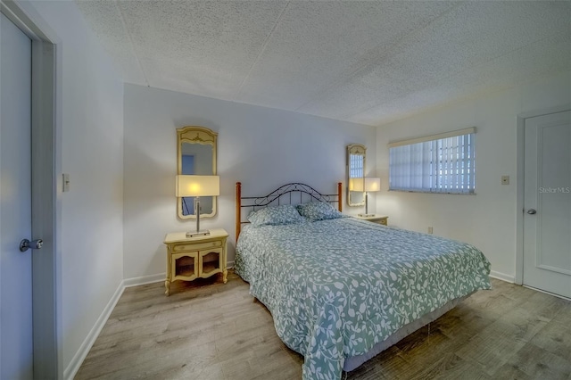 bedroom featuring a textured ceiling and hardwood / wood-style flooring