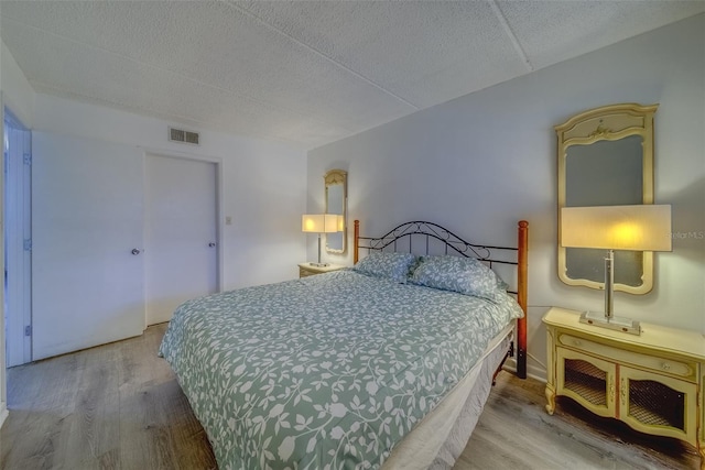 bedroom featuring a textured ceiling and hardwood / wood-style floors