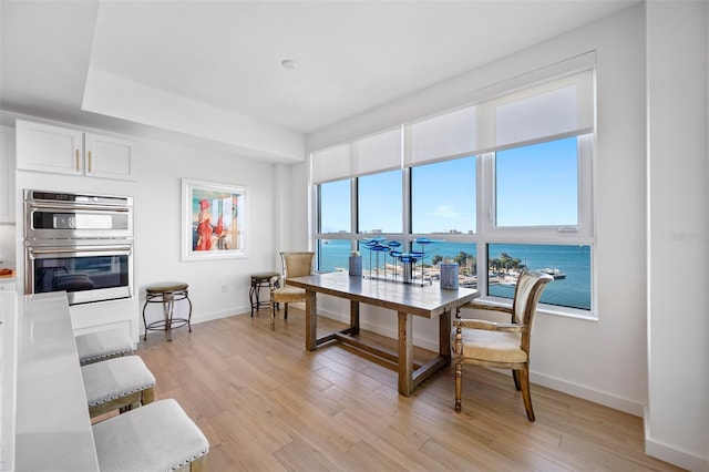 dining space featuring a water view and light hardwood / wood-style floors