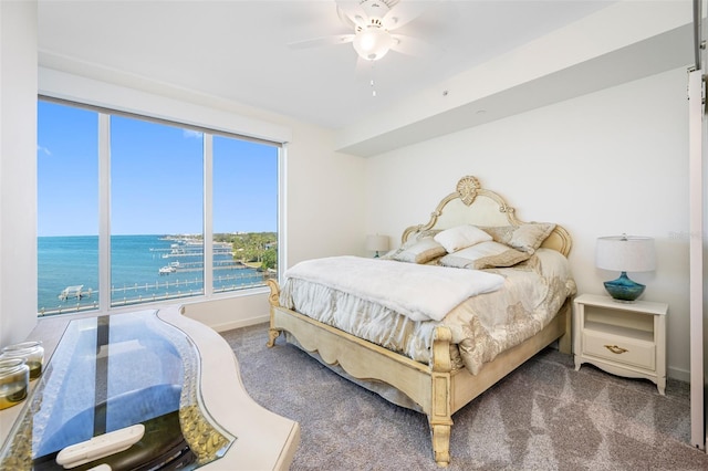 bedroom with a water view, ceiling fan, and carpet floors