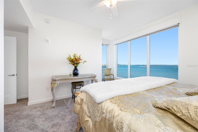 carpeted bedroom with ceiling fan, access to outside, and a water view