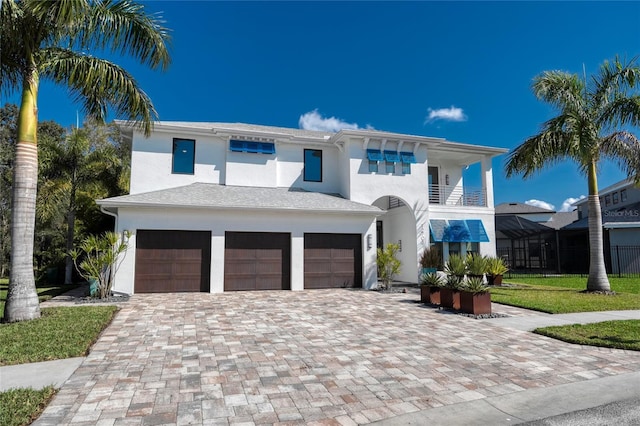 view of front of house with a balcony, a front yard, and a garage