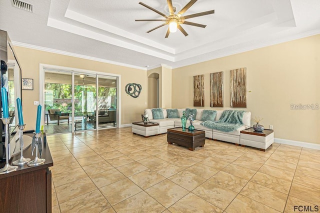 living room featuring a tray ceiling, ceiling fan, and light tile patterned flooring