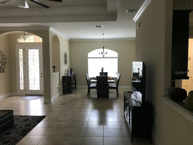 interior space featuring tile patterned flooring, ornamental molding, and a chandelier