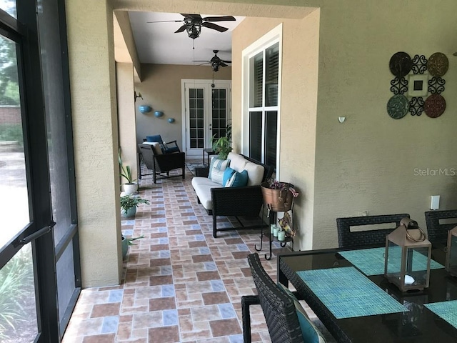 sunroom / solarium with ceiling fan and french doors