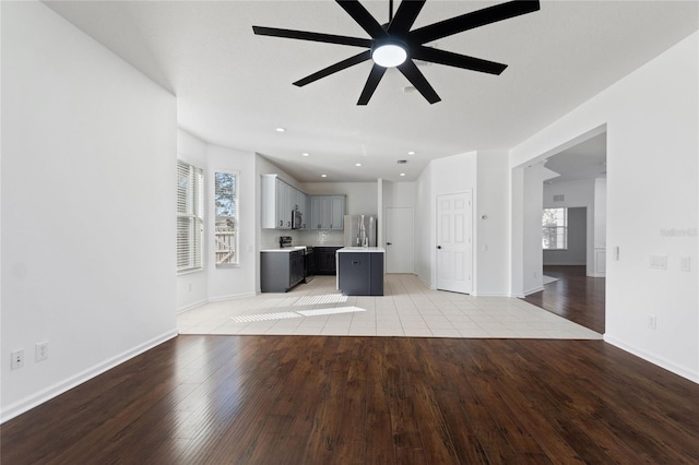 unfurnished living room with ceiling fan and light wood-type flooring