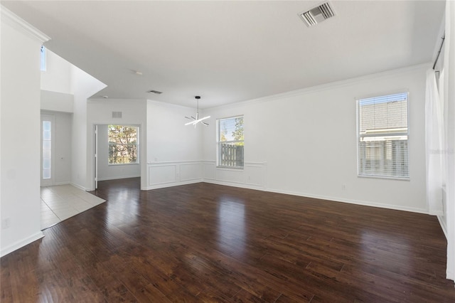 unfurnished room with crown molding, wood-type flooring, and a notable chandelier