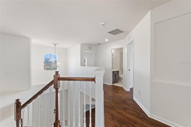 corridor featuring a chandelier and dark hardwood / wood-style floors