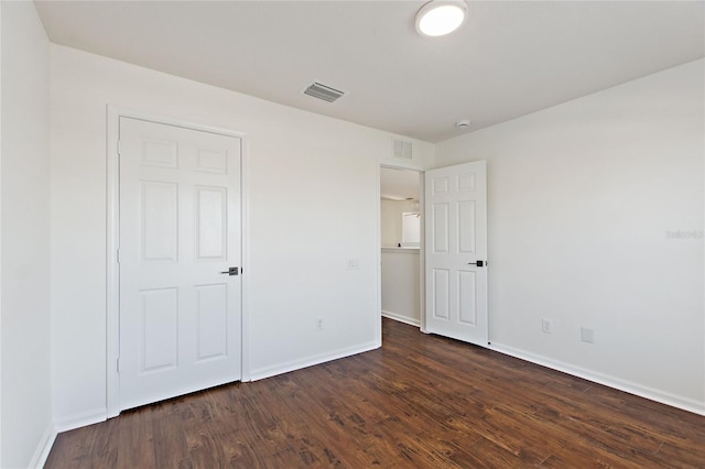 unfurnished bedroom with dark hardwood / wood-style flooring