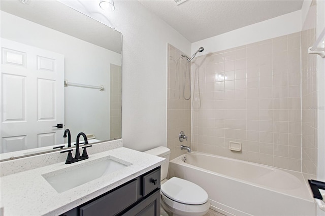 full bathroom featuring toilet, vanity, a textured ceiling, and tiled shower / bath