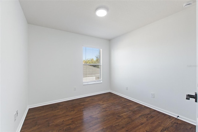 spare room with dark hardwood / wood-style flooring