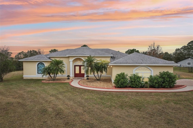 view of front of property featuring french doors and a lawn