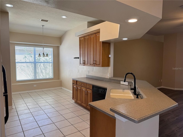 kitchen with pendant lighting, sink, light tile patterned floors, dishwasher, and kitchen peninsula