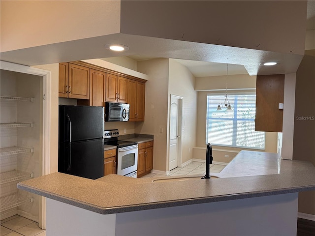 kitchen with black appliances, sink, hanging light fixtures, light tile patterned floors, and kitchen peninsula