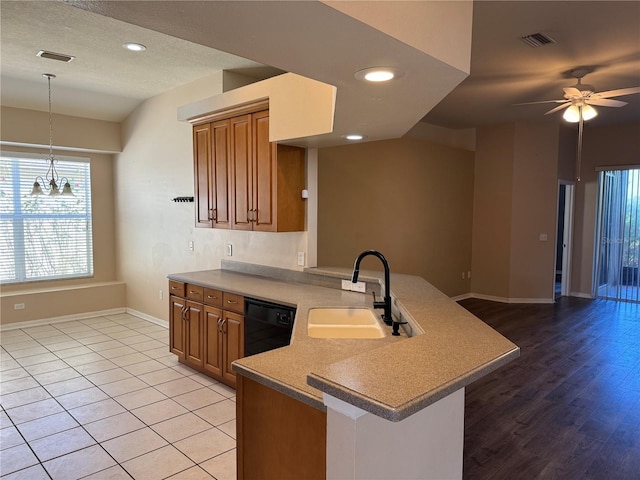 kitchen featuring sink, black dishwasher, kitchen peninsula, pendant lighting, and ceiling fan with notable chandelier