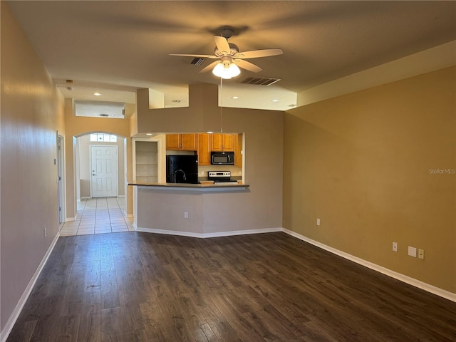 unfurnished living room featuring ceiling fan, a towering ceiling, and dark hardwood / wood-style flooring