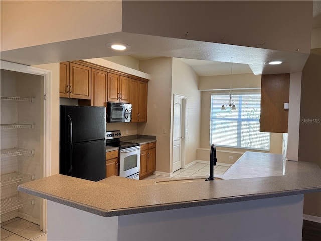 kitchen with light tile patterned floors, sink, black appliances, decorative light fixtures, and kitchen peninsula