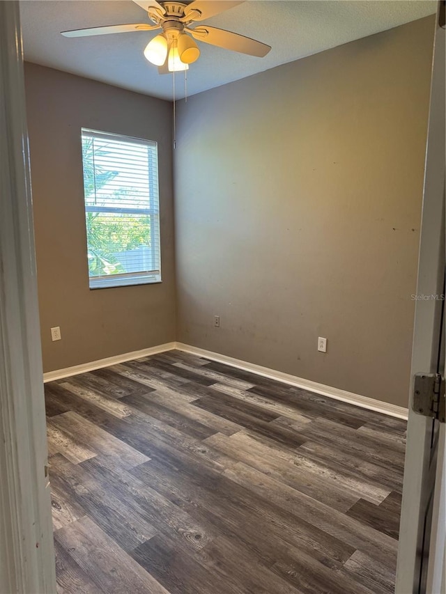 empty room with ceiling fan and dark hardwood / wood-style flooring