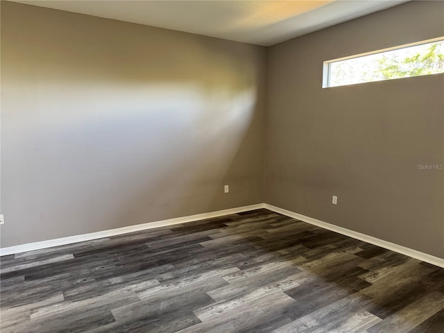 empty room with dark hardwood / wood-style flooring