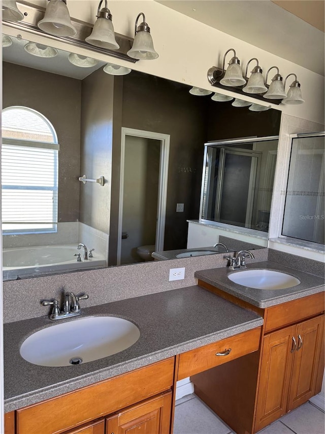 full bathroom featuring vanity, tile patterned flooring, toilet, and separate shower and tub