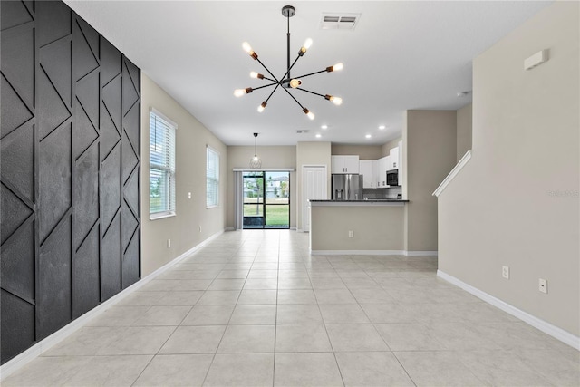 unfurnished living room featuring light tile patterned floors and a chandelier