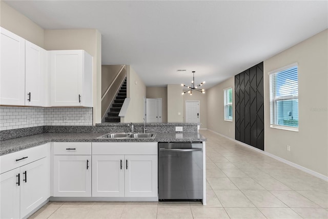 kitchen featuring white cabinetry, sink, an inviting chandelier, stainless steel dishwasher, and pendant lighting