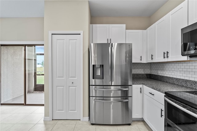 kitchen with white cabinets, stainless steel appliances, tasteful backsplash, and light tile patterned flooring