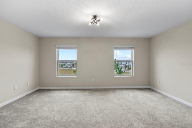 carpeted spare room featuring a textured ceiling