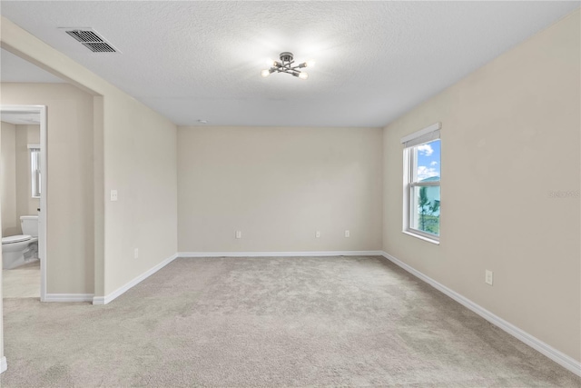 carpeted spare room featuring a textured ceiling