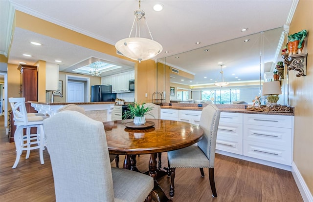 dining area featuring dark hardwood / wood-style flooring and ornamental molding