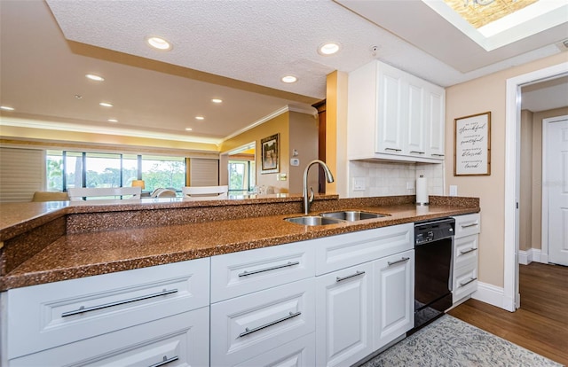 kitchen featuring backsplash, dark stone counters, sink, black dishwasher, and white cabinetry