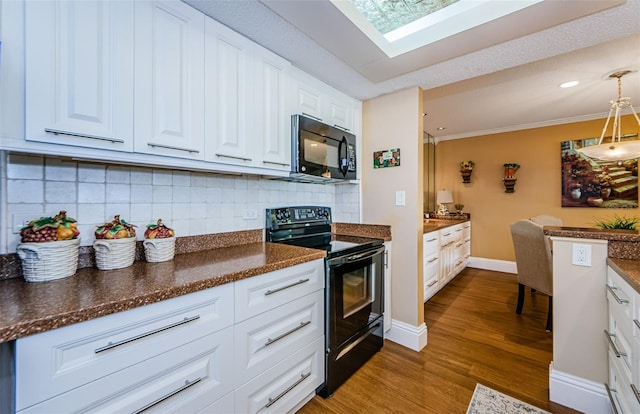 kitchen featuring white cabinets, pendant lighting, tasteful backsplash, and black appliances