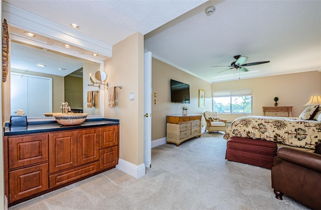 bedroom with light carpet, ceiling fan, ornamental molding, and sink