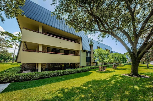 rear view of property featuring a yard and a balcony