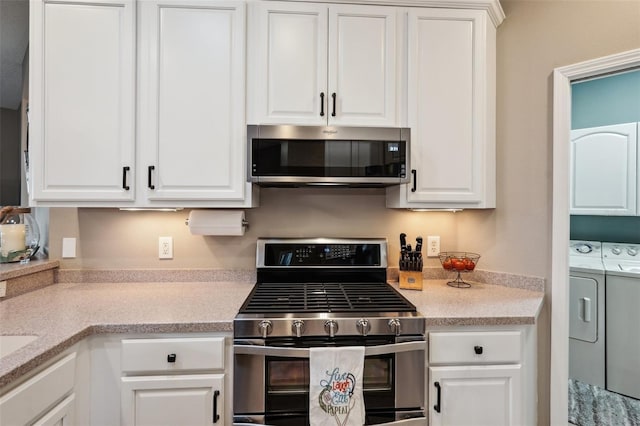 kitchen featuring appliances with stainless steel finishes, separate washer and dryer, and white cabinetry