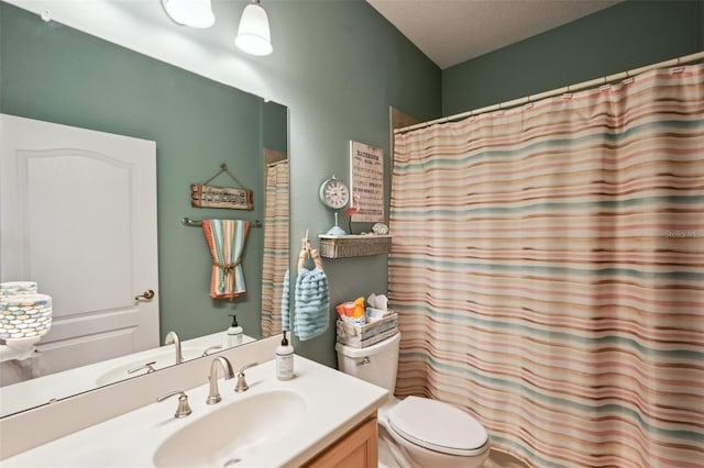 bathroom with toilet, vanity, and a textured ceiling