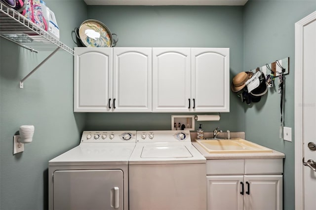 laundry room featuring sink, cabinets, and washer and clothes dryer